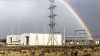 ElectraNet's substation in Robertstown. The two synchronous condensers with the flywheels are housed in the two hangars. There are electricity pylons and a rainbow overhead. 